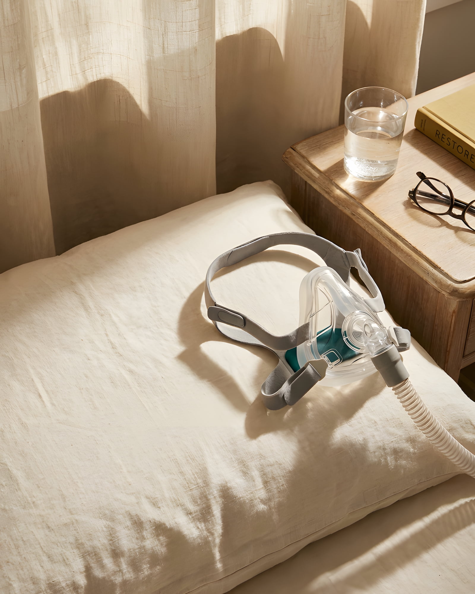 Masque de PPC nasal posé sur un oreiller en lin crème, scène apaisante d'après le réveil